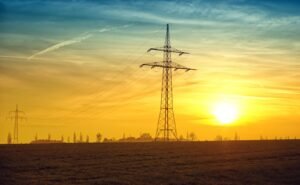 Solar energy suppliers Australia, Silhouetted power lines stretch against a dramatic sunset sky, symbolizing energy and tranquility.
